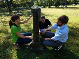Staff of Historic St. Luke's working together to clean an historic gravestone.